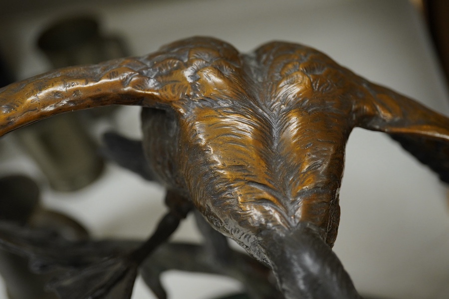 A modern large cast bronze sculpture of two flying geese, on an oval plinth, 90cm wide. Condition - good